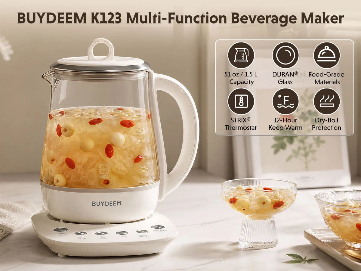 BUYDEEM K123 multi-function beverage maker with a clear glass teapot containing yellow herbal tea and red goji berries, sitting on a white base. The image includes a feature icon panel on the right and two small glass cups of the prepared tea in the foreground.
