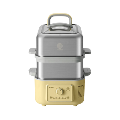 A yellow two-tier food steamer  with a brushed stainless steel upper pot and a cream-colored base, featuring a top handle and a control dial on the front.